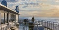 Tourist while the boat is sailing. Young woman are looking at the sea as she stand at the edge of the ship`s deck