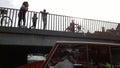 A tourist boat sails under the bridge in Copenhagen. On the bridge people watching on the canal.