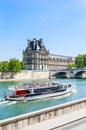 A tourist boat and tourists near Flora Pavilion ot the Louvre