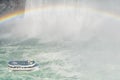 Tourist boat under rainbow in the mist from Niagara falls