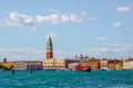 a tourist boating looking like a pirate ship is passing in front of the St. Mark's Square with Campanile and