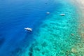 Tourist boats over the wall of a fringing coral reef in Indonesia