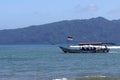 Tourist boats pass by with Indonesian flags carrying passengers