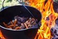 Tourist bowler with food on bonfire, cooking in the hike, outdoor activities. Preparation of pilaf. Royalty Free Stock Photo