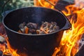 Tourist bowler with food on bonfire, cooking in the hike, outdoor activities. Preparation of pilaf. Royalty Free Stock Photo