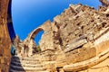 Tourist bus drives along central city gate - ancient stone arch gate with ruins of Vespasian monument Royalty Free Stock Photo