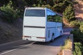 Tourist bus moves along mountain road Royalty Free Stock Photo