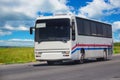 Tourist bus moves along a suburban highway Royalty Free Stock Photo