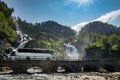 Tourist bus traveling on the road Latefossen Waterfall Odda Norway. Latefoss is a powerful, twin waterfall Royalty Free Stock Photo