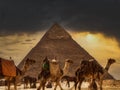 Tourist bustle with camels and people in front of a pyramid