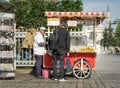 Tourist buying fast food meal from a traditional Turkish chestnut and corn cart in Sultan Ahmed Square, Istanbul