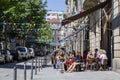 Tourist on cafe terrace on street decorated with flags for popular saints festival