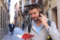 Tourist calling by phone while looking at tourism guide or dictionary Royalty Free Stock Photo