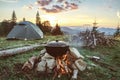 Tourist camp with fire, gree tent and firewood