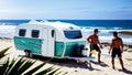 Tourist caravan trailer parked on the sandy beach next to palm trees. In concept of vacation travel, tourism Royalty Free Stock Photo