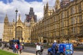 Tourist and cars in front of Westminster Houses of Parliament.