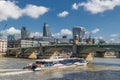 Tourist catamaran boat floats near Southwark bridge