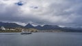 A tourist catamaran is sailing along the bay.