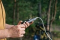 A tourist charges a smartphone with a power bank on the background of a bicycle in forest