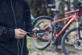 A tourist charges a smartphone with a power bank on the background of a bicycle in nature