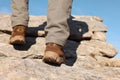 Tourist climbing on cliff, closeup of legs