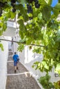 Tourist climbing sloped street of Alpujarras town, Spain