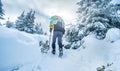 Tourist climbing snowy mountain in winter