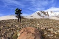 Tourist climbs the rocky slope of the mountain to the snow-capped peak