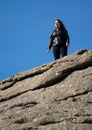 Tourist climbs up the granite slopes of Haytor Rocks