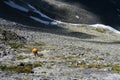 Tourist climbs up the stones in the mountains. Going up the rocky moraine