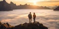 Tourist couple on top of cliff with sea of clouds in the background during sunset