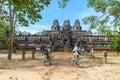 Tourist couple cycling around Angkor temple, Cambodia. Ta Keo building ruins in the jungle. Eco friendly tourism traveling Royalty Free Stock Photo