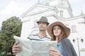 Tourist couple holding map outside St. Casimir Church, Warsaw, Poland