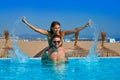 Tourist couple piggyback in infinity pool Royalty Free Stock Photo
