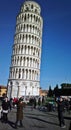 Tourist couple pose for photos in front of Leaning Tower of Pisa