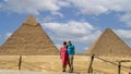 Tourist couple, The Pyramid of Khafre and The Great Pyramid of Khufu photographed from the 9 Pyramids Lounge in Giza, Egypt.