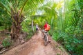 Tourist couple riding bicycle in the Mekong Delta region, Ben Tre, South Vietnam. Woman and man having fun cycling on trail among