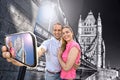 Tourist couple taking selfie against Tower Bridge in London, England, UK Royalty Free Stock Photo