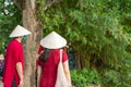 Tourist couple wearing Vietnamese traditional dress Ao Dai with The Huc bridge at Hoang Kiem lake on background