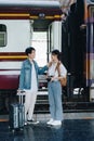 Tourist couples showing their love and happiness in a sweet way while waiting for their journey at the train station.