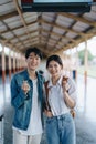 Tourist couples showing their love and happiness in a sweet way while waiting for their journey at the train station.