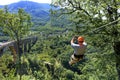 A tourist crosses over a long cable car over a mountain and a forest across the Tiara River Royalty Free Stock Photo