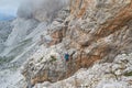 Tourist crossing a suspended wire bridge on via ferrata Cesare Piazzetta, on the way up to Piz Boe peak, on a Summer adventure Royalty Free Stock Photo