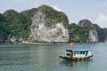 Tourist cruise ship sailing among limestone mountains in Halong Bay, Vietnam