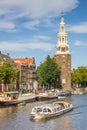 Tourist cruiseboat and historical tower in Amsterdam