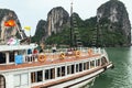 Tourist cruising boat over the emerald water with towering limestone islands that have growing green trees on it in summer. Royalty Free Stock Photo