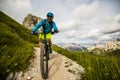 Tourist cycling in Cortina d`Ampezzo, stunning Cinque Torri and