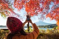 A tourist do photography Fujisan with maple leaves