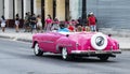 Tourist driven in vintage pink Chevy convertible in Havana Cuba