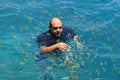 Tourist enjoy with feeding fish in a tropical sea at Phi Phi isl Royalty Free Stock Photo